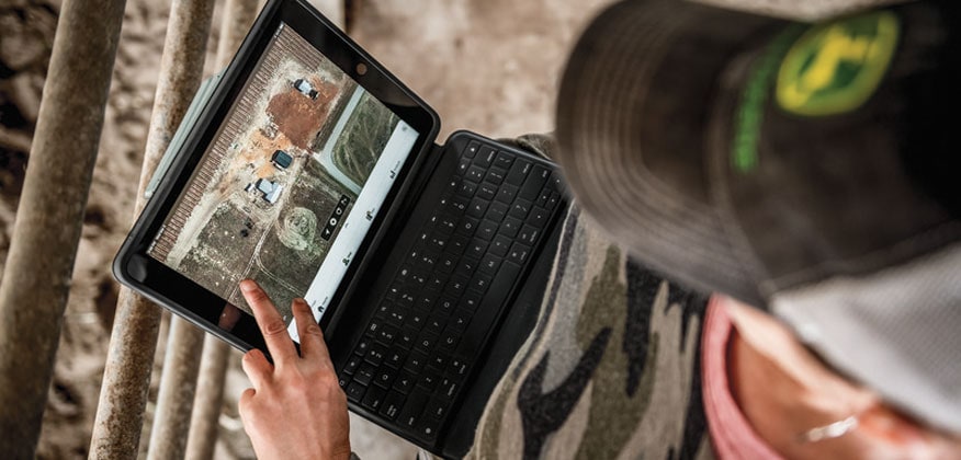 Image of operator using laptop connected to tractor