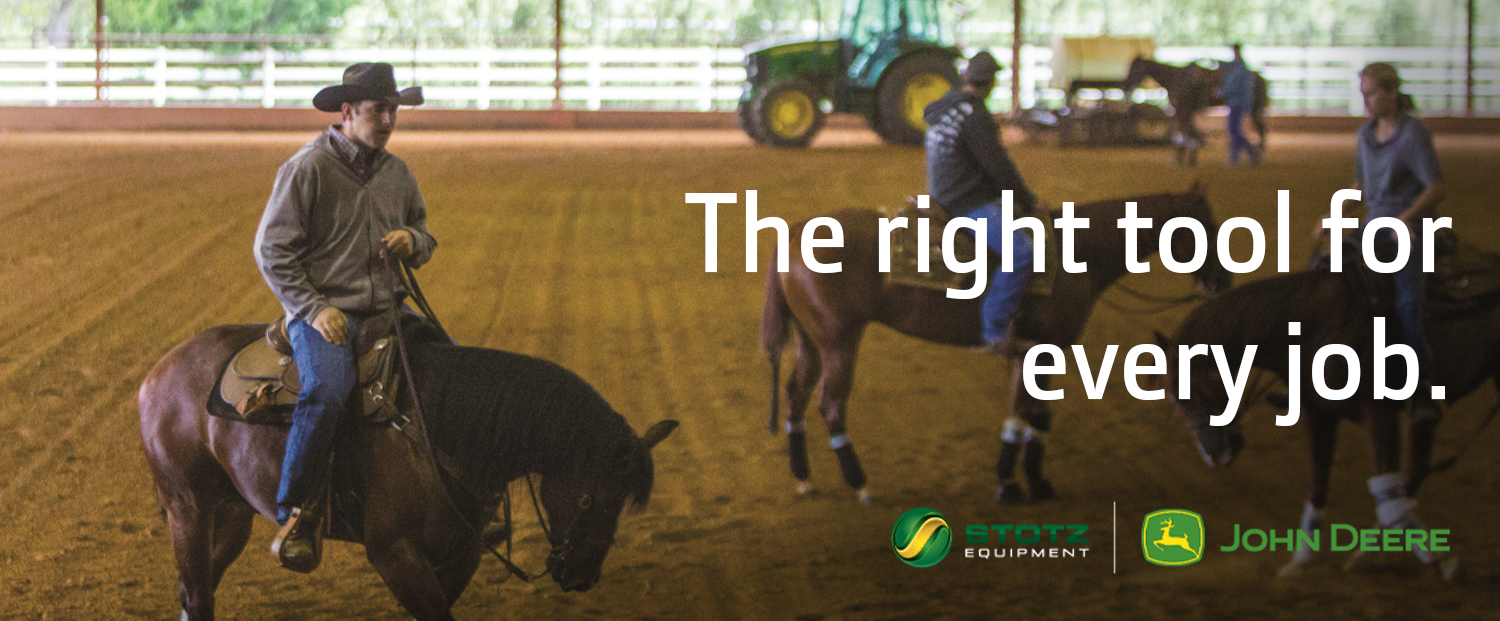 Image of people on horseback in arena, John Deere tractor in background.