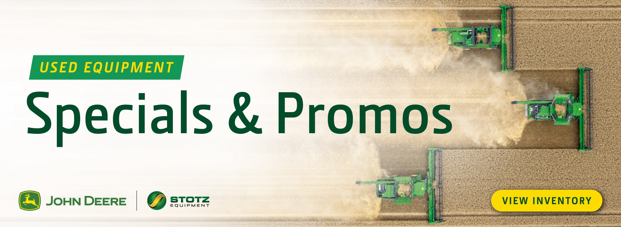Aerial view of four John Deere combines harvesting a field with dust trails, featuring a banner that
