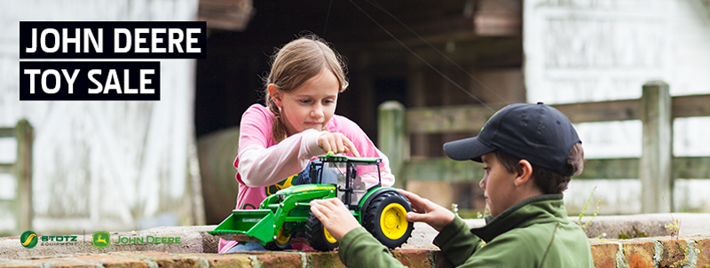 Image of children playing with model john deere tractor.